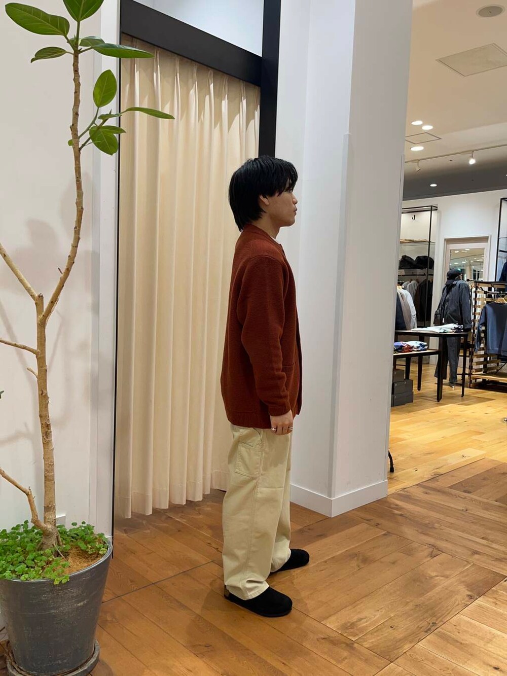 オレンジ系のカーディガン/ボレロ、ベージュ系のその他パンツ、ベージュ系のダウンジャケット/コートを着用したメンズの秋コーディネートの8枚目の写真