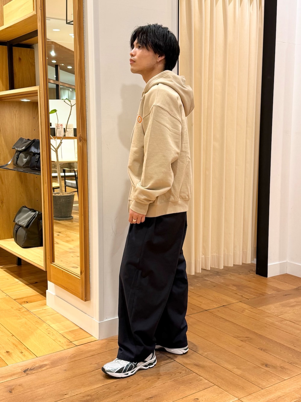 ベージュ系のパーカー、ブルー系のその他パンツを着用したメンズの春コーディネートの3枚目の写真