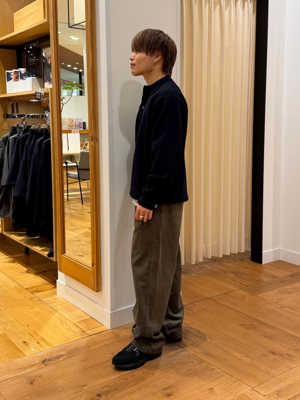 ブルー系のニット/セーター、ブラウン系のその他パンツ、ブラック系のスニーカーを着用したメンズの秋コーディネートの2枚目の写真