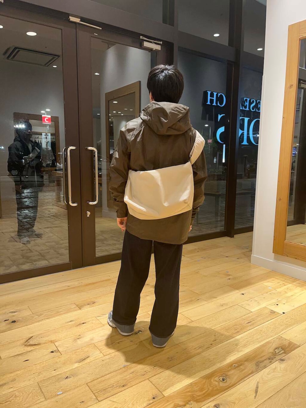 ベージュ系のショルダーバッグ、ホワイト系のTシャツ/カットソー、ブルー系のデニムパンツを着用したメンズの夏コーディネートの3枚目の写真