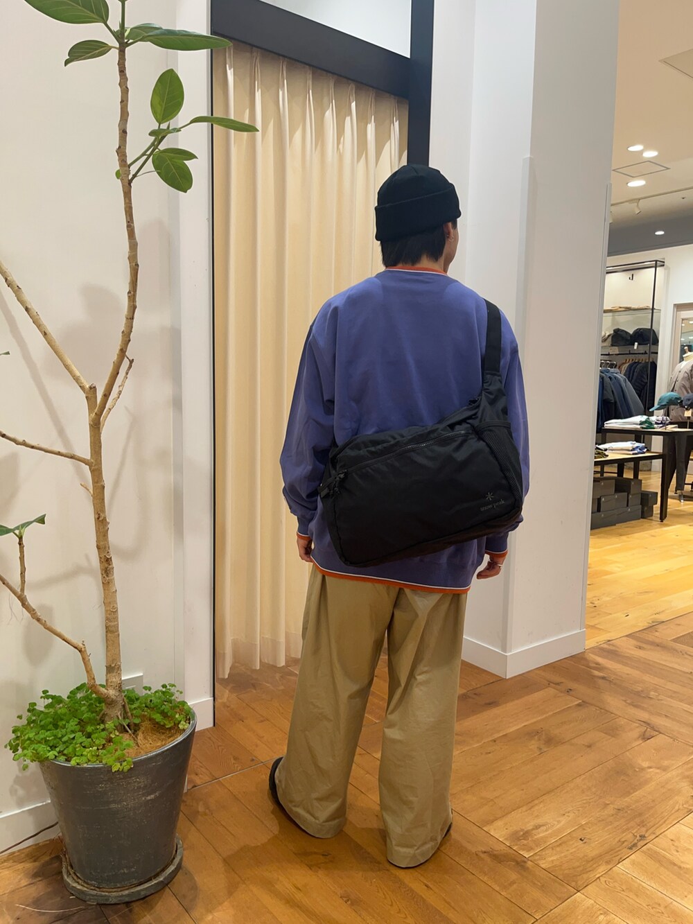 パープル系のスウェット、ブラック系のショルダーバッグ、ブラック系のニットキャップ/ビーニーを着用したメンズの秋コーディネートの3枚目の写真