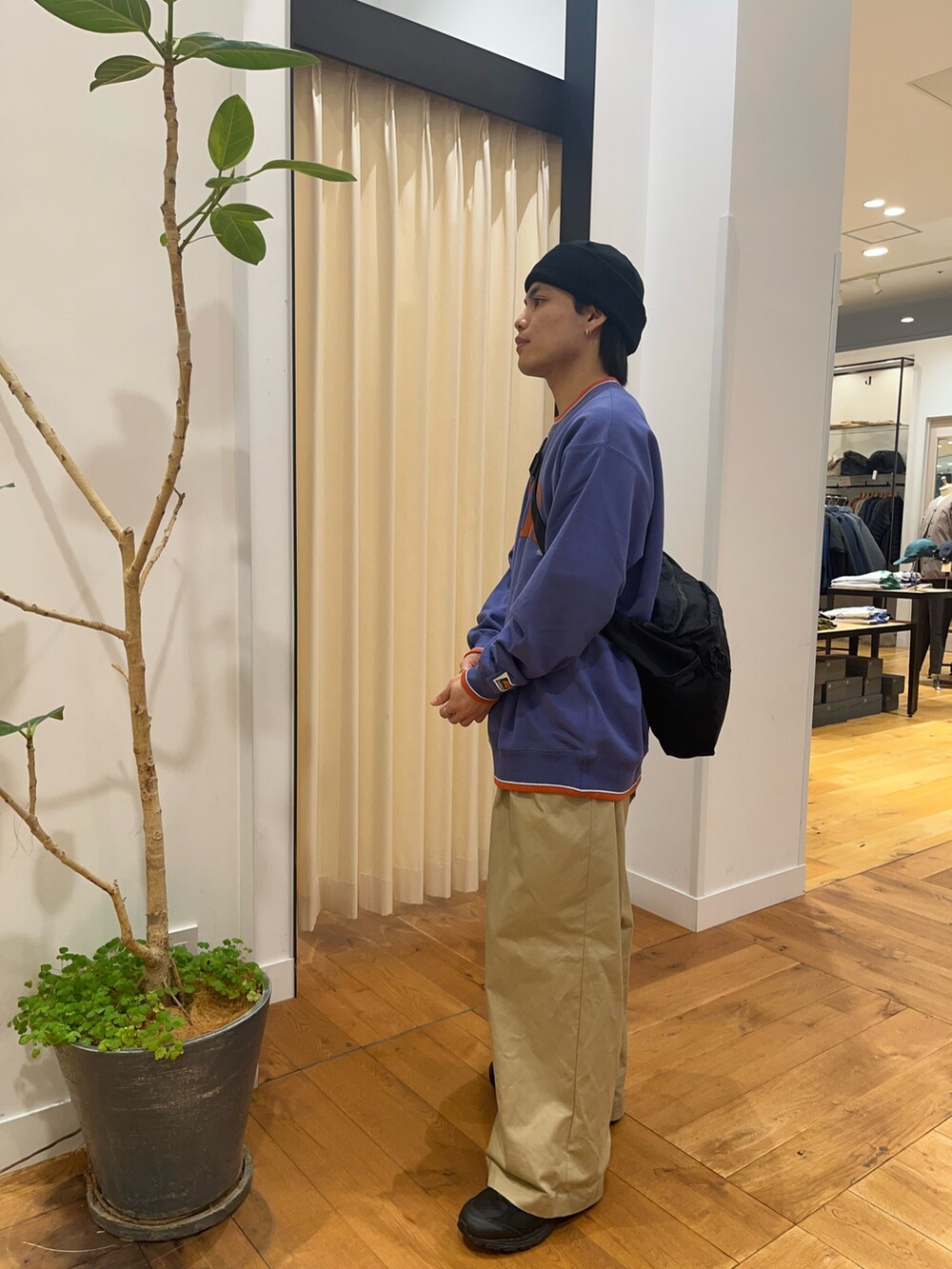 パープル系のスウェット、ブラック系のショルダーバッグ、ブラック系のニットキャップ/ビーニーを着用したメンズの秋コーディネートの2枚目の写真