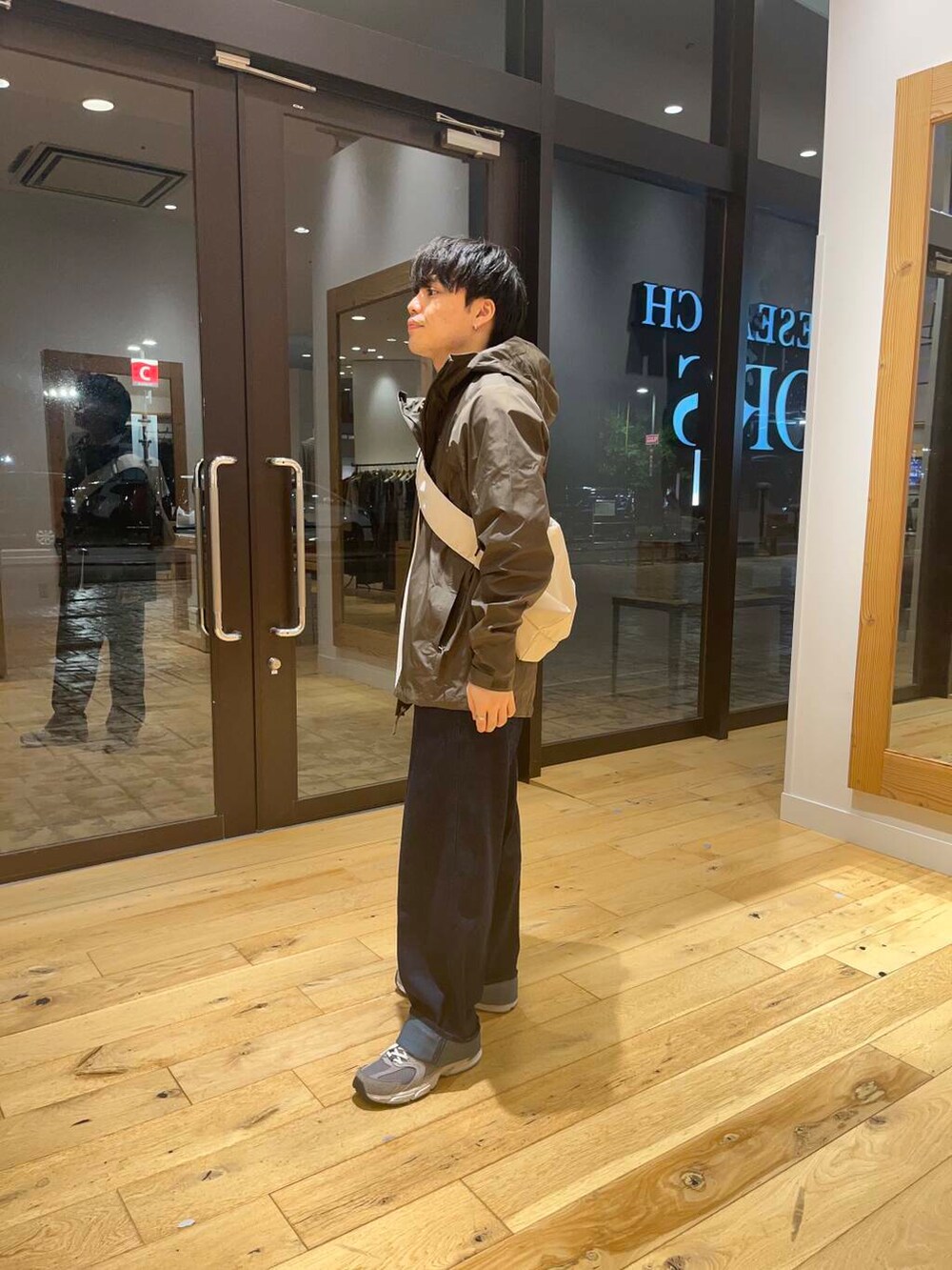 ベージュ系のショルダーバッグ、ホワイト系のTシャツ/カットソー、ブルー系のデニムパンツを着用したメンズの夏コーディネートの2枚目の写真