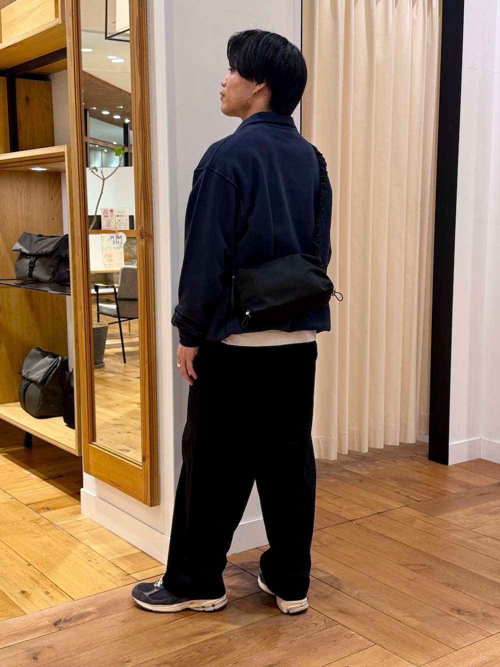 ブルー系のスウェット、ブラック系のショルダーバッグを着用したメンズの春コーディネートの4枚目の写真