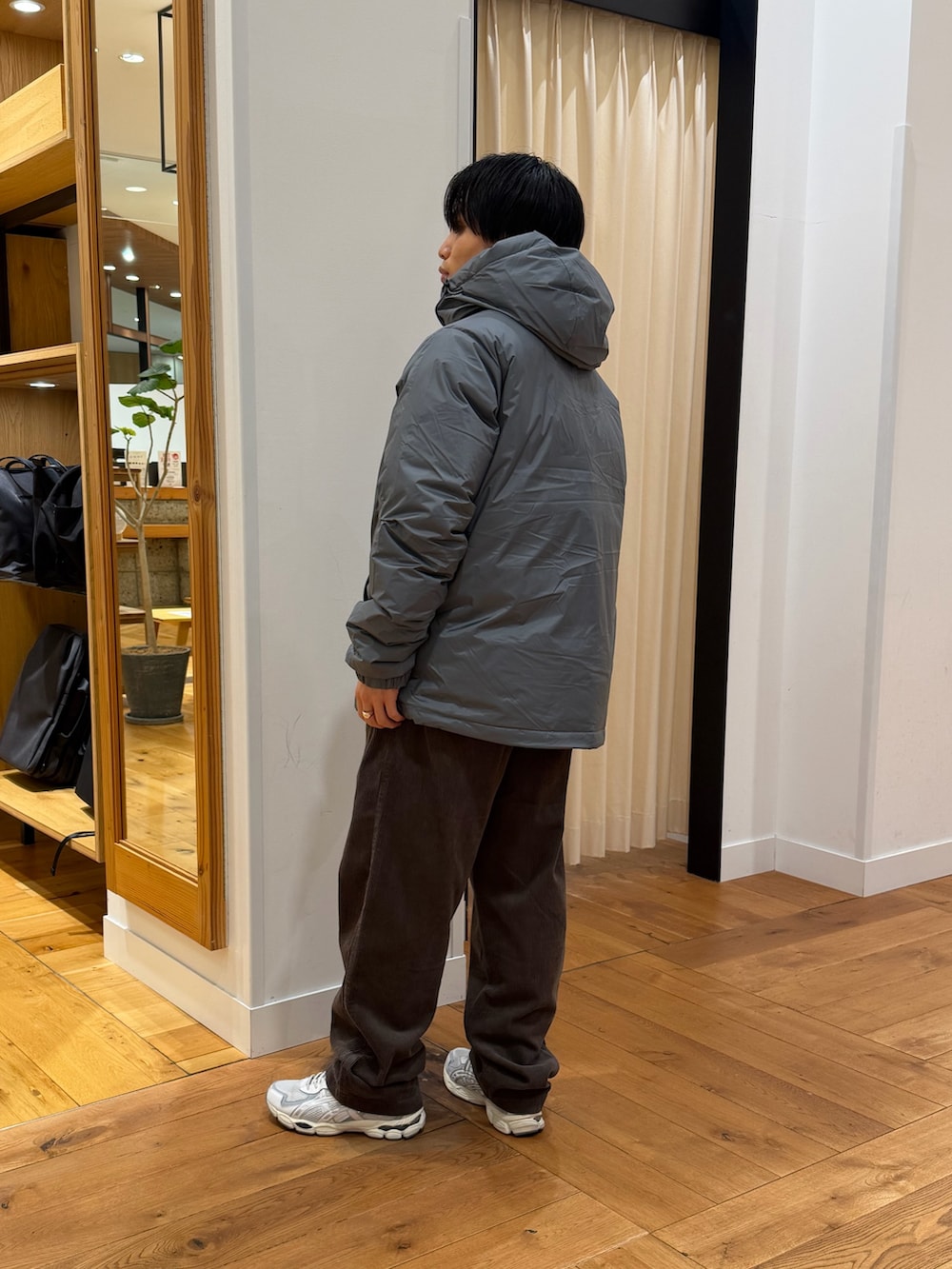 グレー系のダウンジャケット/コート、ブラウン系のその他パンツを着用したメンズの秋コーディネートの2枚目の写真