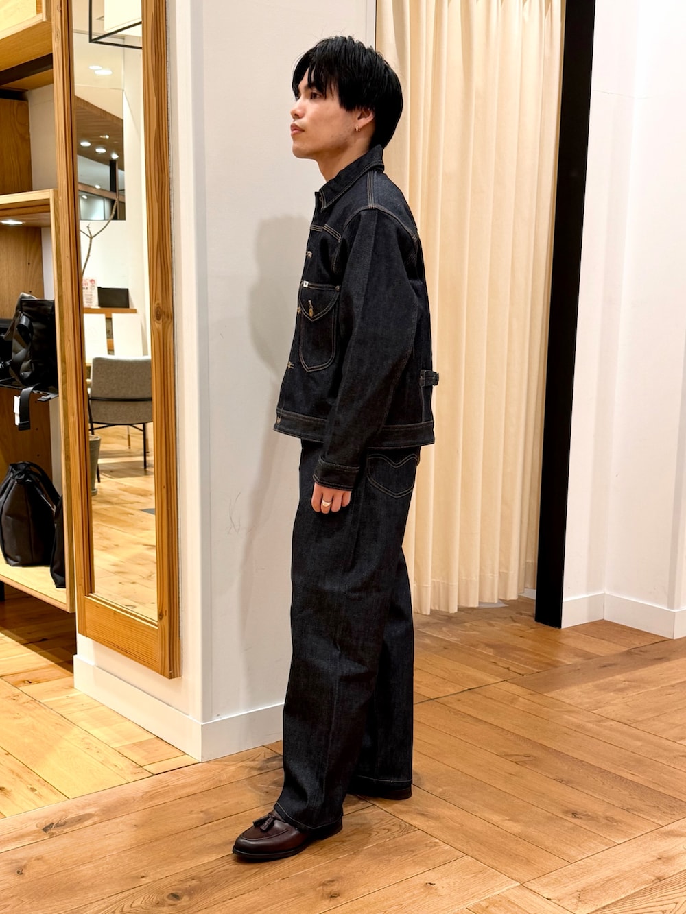 ブルー系のデニムジャケット、ブルー系のデニムパンツ、ブラウン系のドレスシューズを着用したメンズの冬コーディネートの3枚目の写真