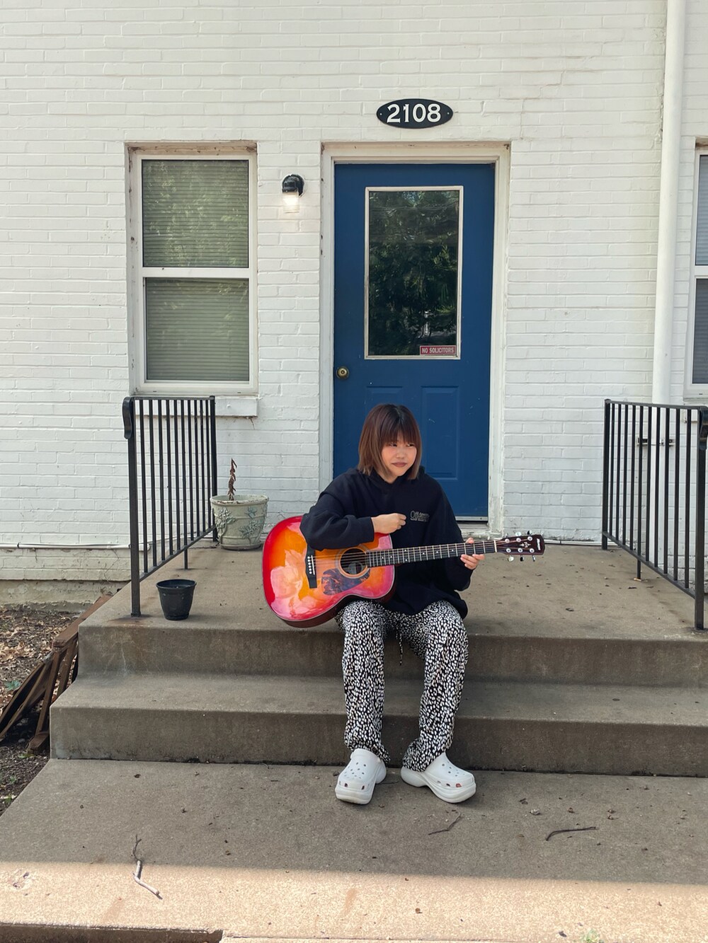 ブラック系のスウェット、ブラック系のパンツ、ホワイト系のサンダルを着用したレディースの秋コーディネートの2枚目の写真