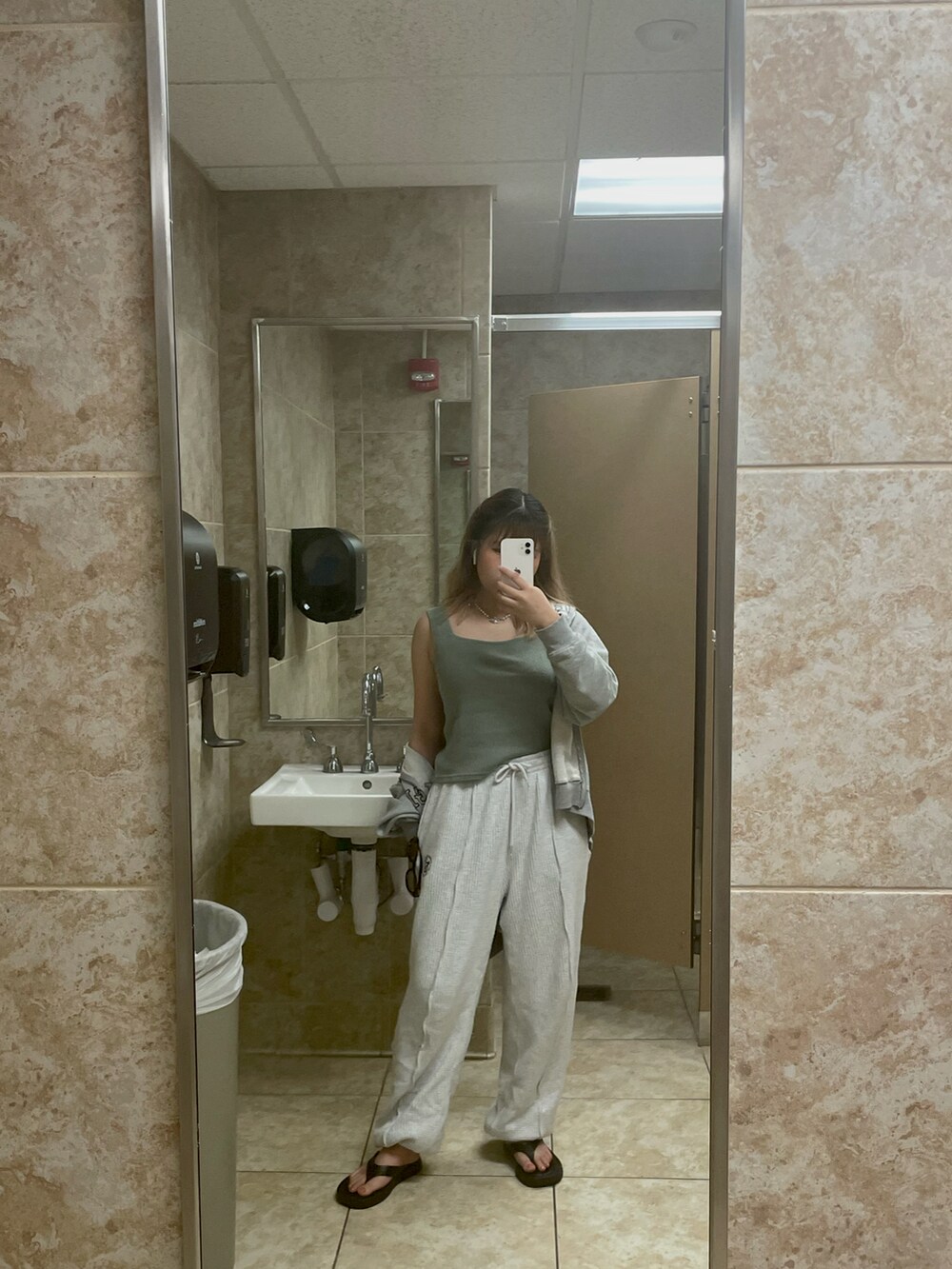 グレー系のパーカー、グレー系のスウェットパンツ、ブラウン系のサングラスを着用したレディースの春コーディネートの2枚目の写真