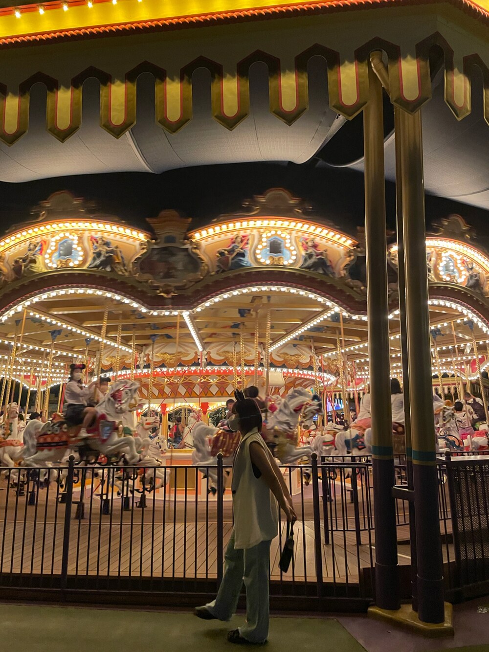 ブラック系のキャミソール、ホワイト系のベスト、ブルー系のデニムパンツを着用したレディースの秋コーディネートの2枚目の写真