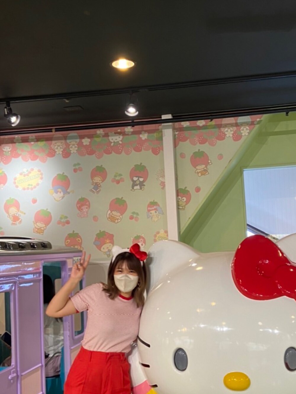 ブラック系のハンドバッグ、レッド系のTシャツ/カットソー、レッド系のスラックスを着用したレディースの秋コーディネートの4枚目の写真