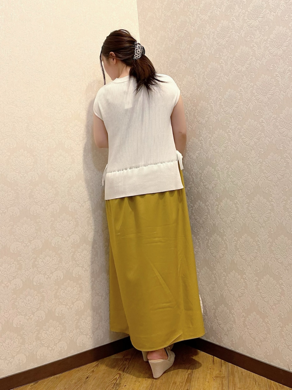 イエロー系のワンピース、ホワイト系のトートバッグ、ベージュ系のサンダルを着用したレディースの春コーディネートの3枚目の写真