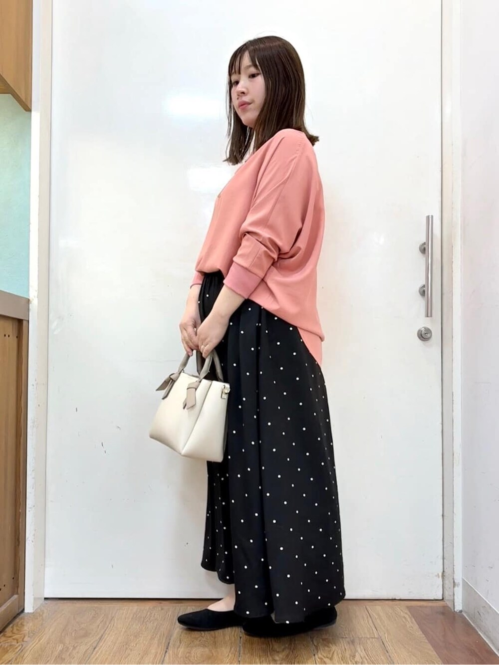 ピンク系のシャツ/ブラウス、ブラック系のスカート、ブラック系のパンプスを着用したレディースの春コーディネートの3枚目の写真