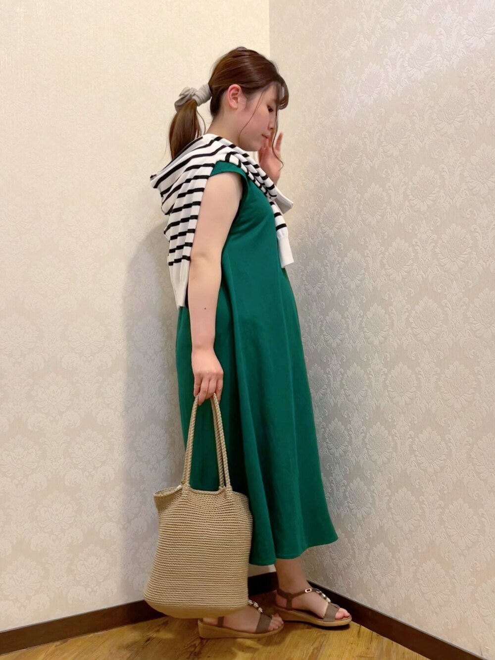 グリーン系のワンピース、ホワイト系のカーディガン/ボレロ、ベージュ系のトートバッグを着用したレディースの夏コーディネートの2枚目の写真