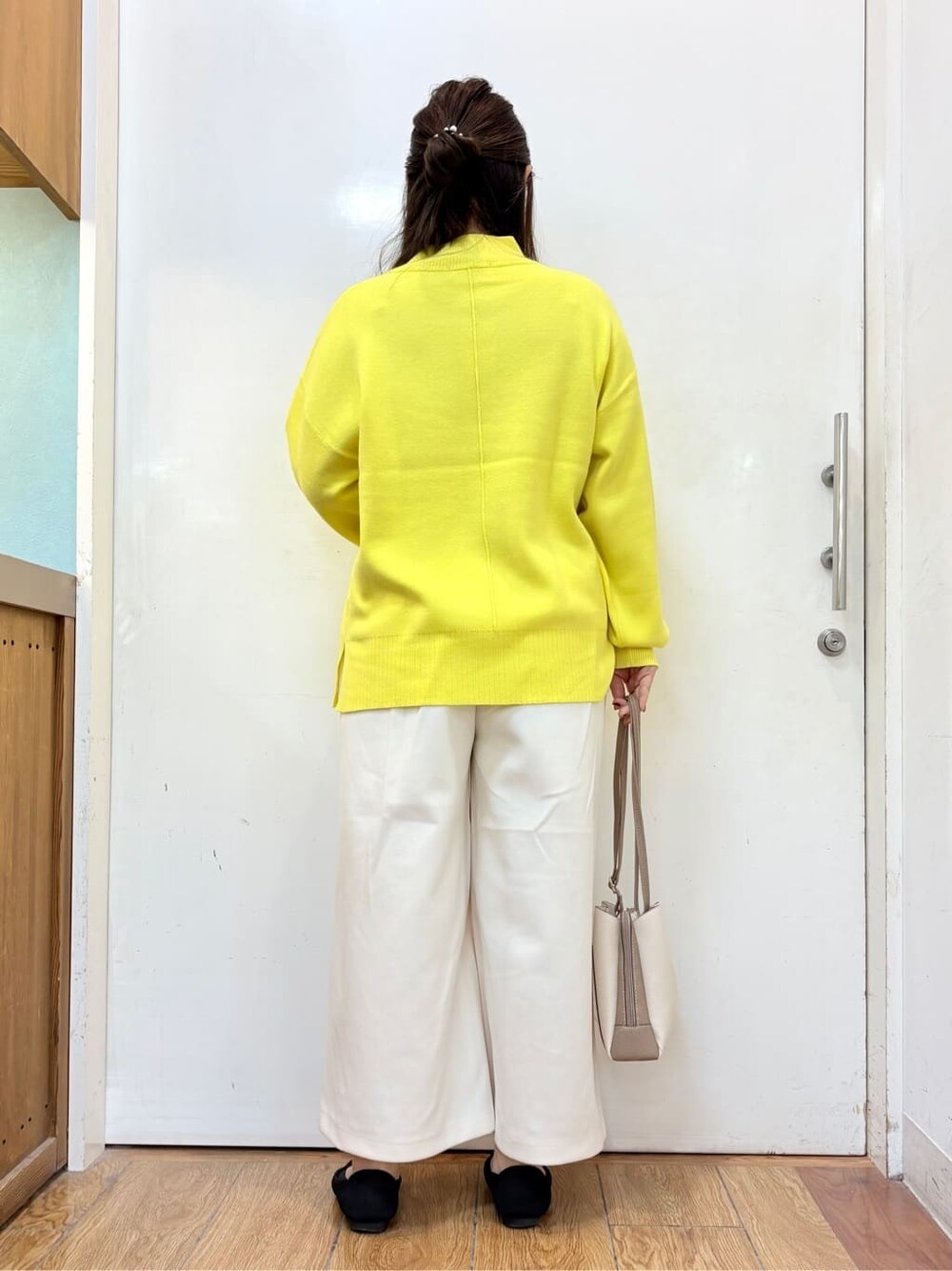 イエロー系のニット/セーター、ホワイト系のその他パンツ、ブラック系のパンプスを着用したレディースの冬コーディネートの3枚目の写真
