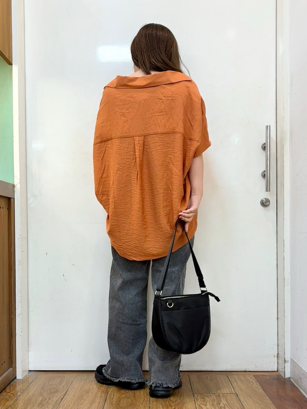 オレンジ系のシャツ/ブラウス、ブラック系のデニムパンツ、ブラック系のショルダーバッグを着用したレディースの秋コーディネートの3枚目の写真