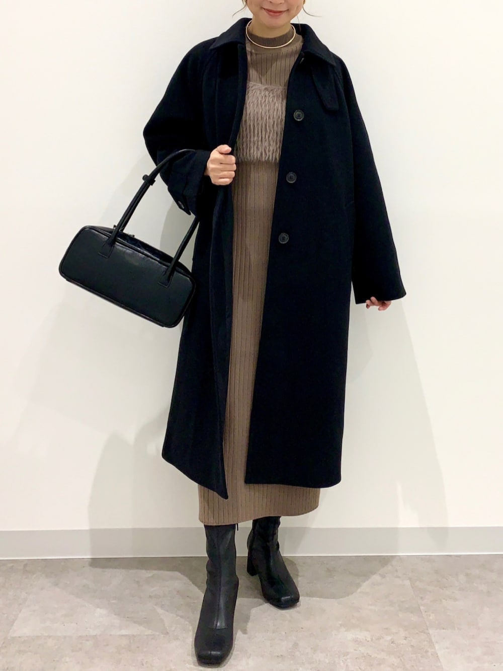 ブラウン系のワンピースを着用したレディースの冬コーディネートの2枚目の写真