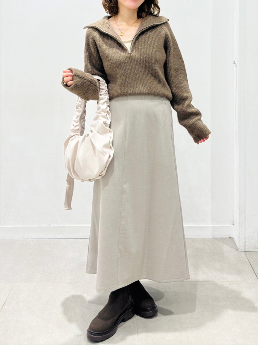 ブラウン系のブーツを着用したレディースの秋コーディネートの2枚目の写真