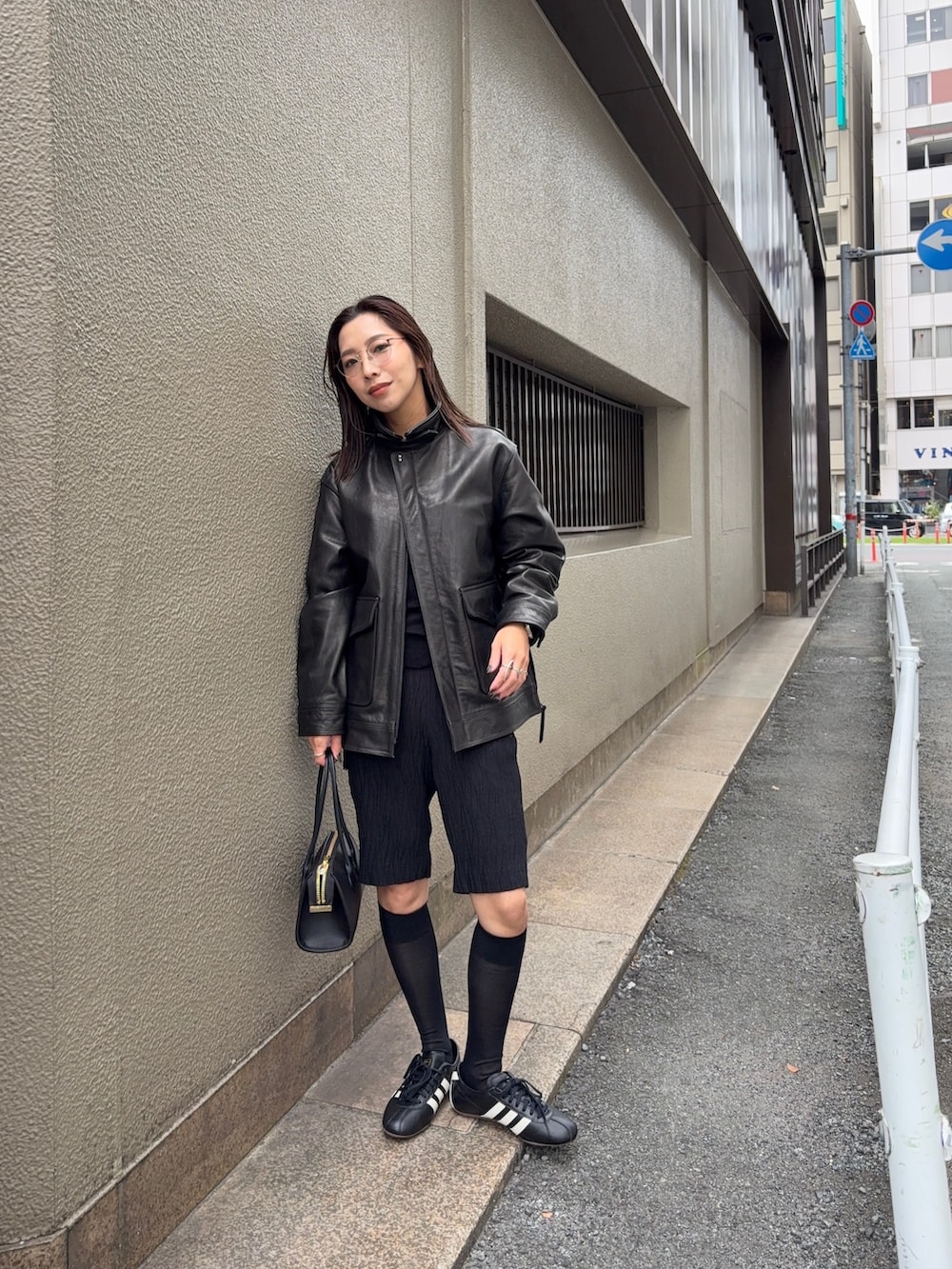 ブラック系のその他アウター、ブラック系のショルダーバッグ、ブラック系のスニーカーを着用したレディースの秋コーディネートの3枚目の写真