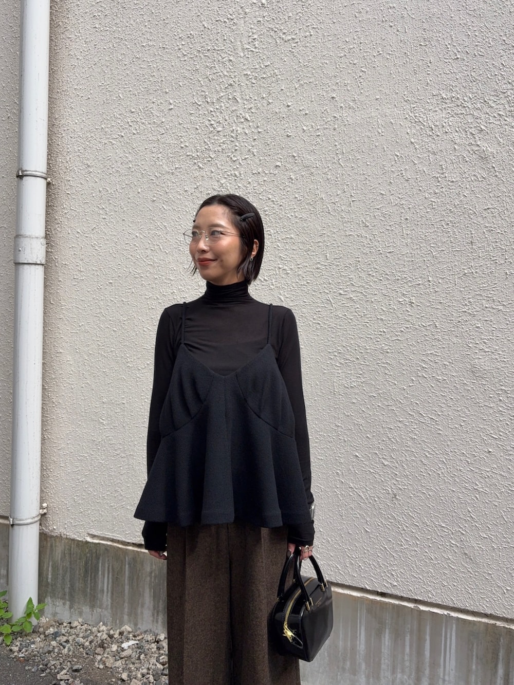 ブラック系のTシャツ/カットソー、イエロー系のその他パンツ、ブラック系のショルダーバッグを着用したレディースの秋コーディネートの2枚目の写真