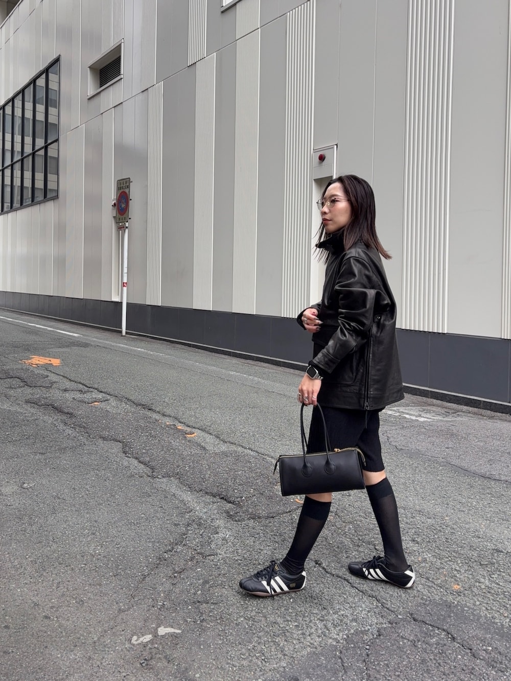 ブラック系のその他アウター、ブラック系のショルダーバッグ、ブラック系のスニーカーを着用したレディースの秋コーディネートの2枚目の写真
