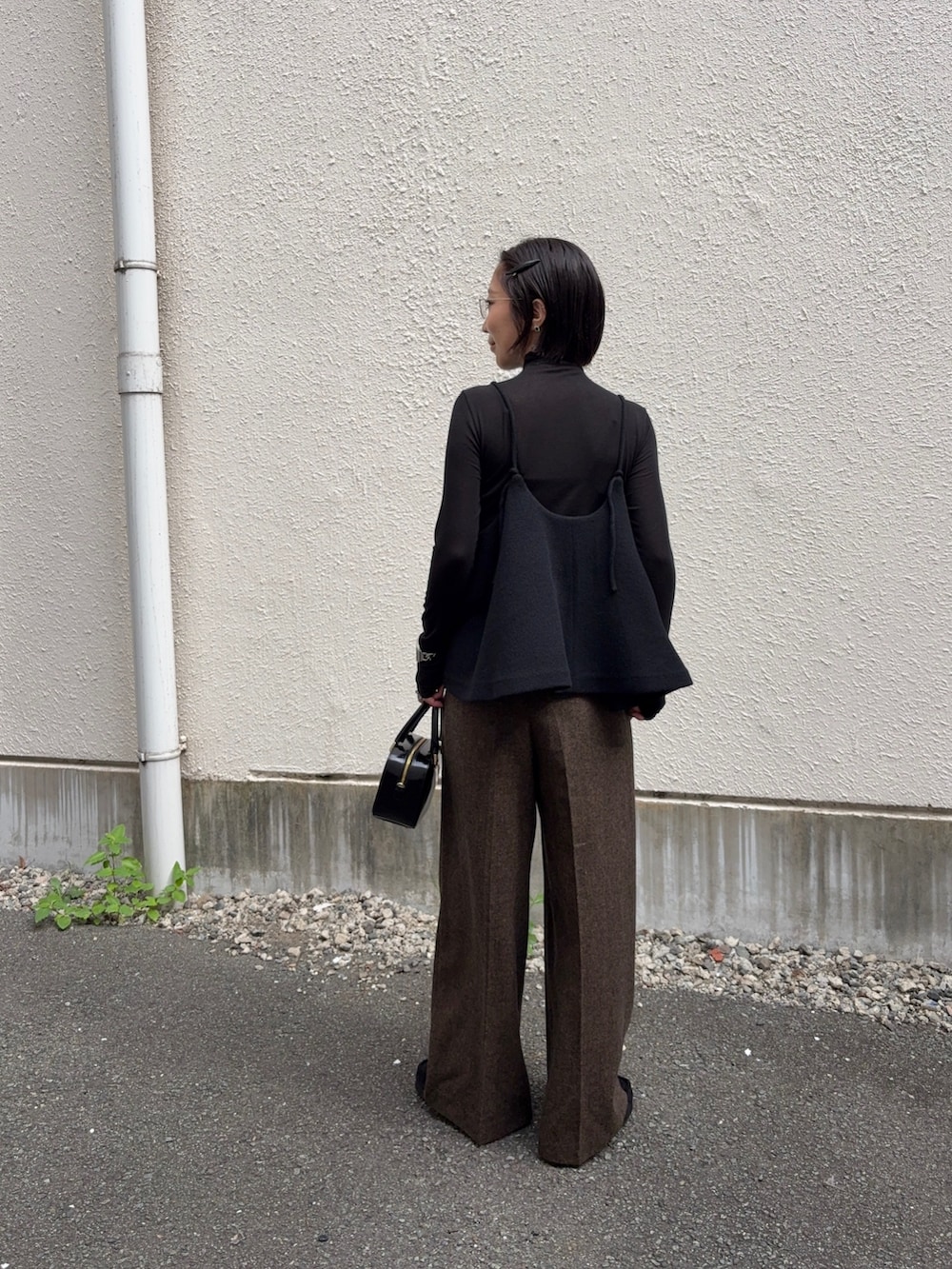 ブラック系のTシャツ/カットソー、イエロー系のその他パンツ、ブラック系のショルダーバッグを着用したレディースの秋コーディネートの5枚目の写真