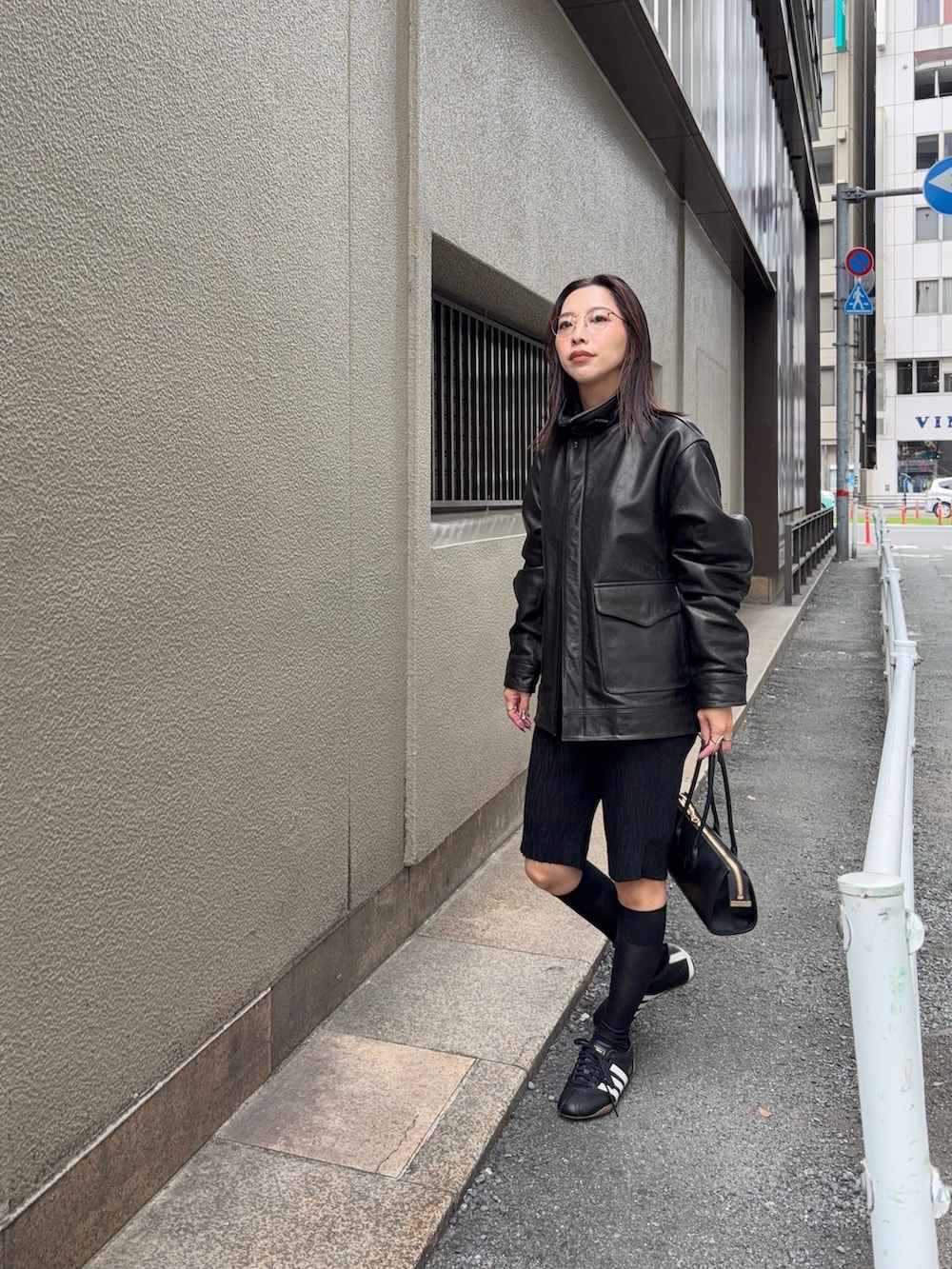 ブラック系のその他アウター、ブラック系のショルダーバッグ、ブラック系のスニーカーを着用したレディースの秋コーディネートの5枚目の写真