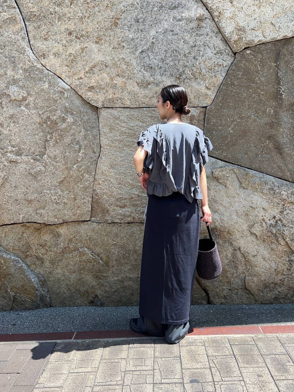 ブルー系のスカート、ブラック系のかごバッグ、グレー系のその他パンツを着用したレディースの夏コーディネートの4枚目の写真