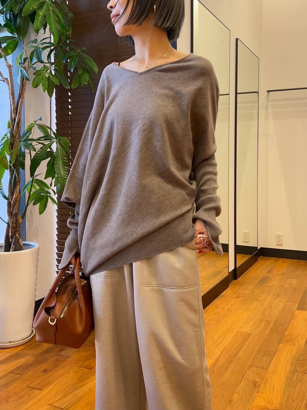 グレー系のその他パンツ、ブラウン系のブーツ、グレー系のニット/セーターを着用したレディースの秋コーディネートの2枚目の写真