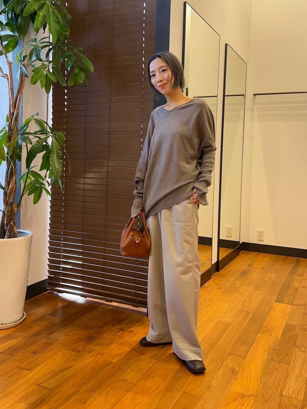 グレー系のその他パンツ、ブラウン系のブーツ、グレー系のニット/セーターを着用したレディースの秋コーディネートの4枚目の写真