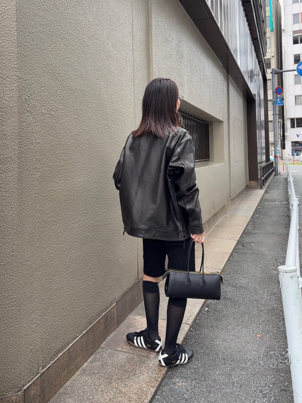 ブラック系のその他アウター、ブラック系のショルダーバッグ、ブラック系のスニーカーを着用したレディースの秋コーディネートの4枚目の写真