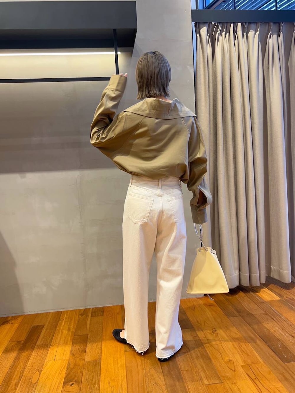 イエロー系のTシャツ/カットソー、イエロー系のショルダーバッグ、ホワイト系のデニムパンツを着用したレディースの秋コーディネートの5枚目の写真