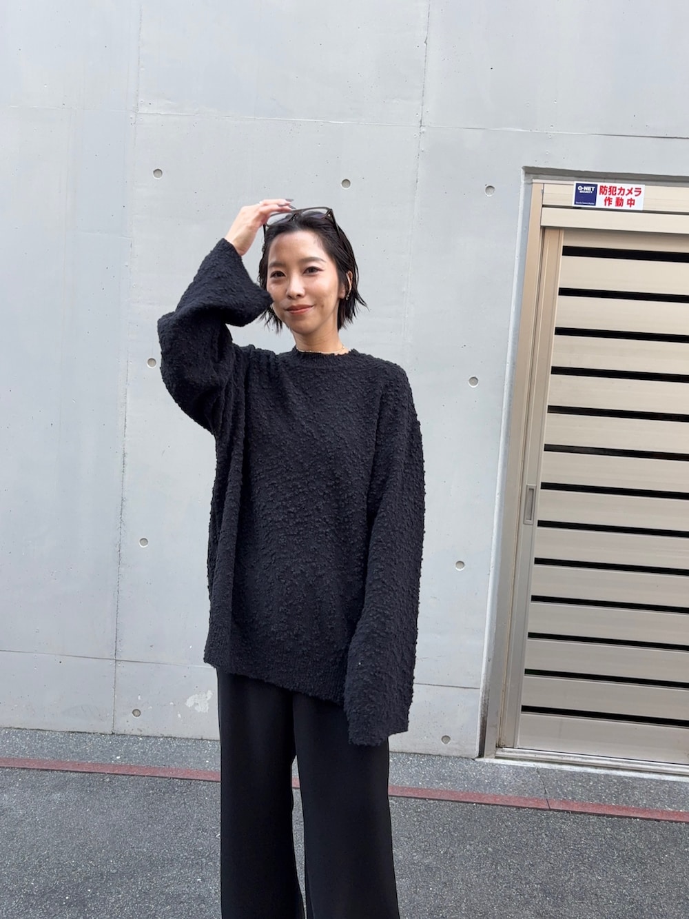 ブラック系のニット/セーター、ブラウン系のダウンベスト、ブラック系のその他パンツを着用したレディースの秋コーディネートの5枚目の写真