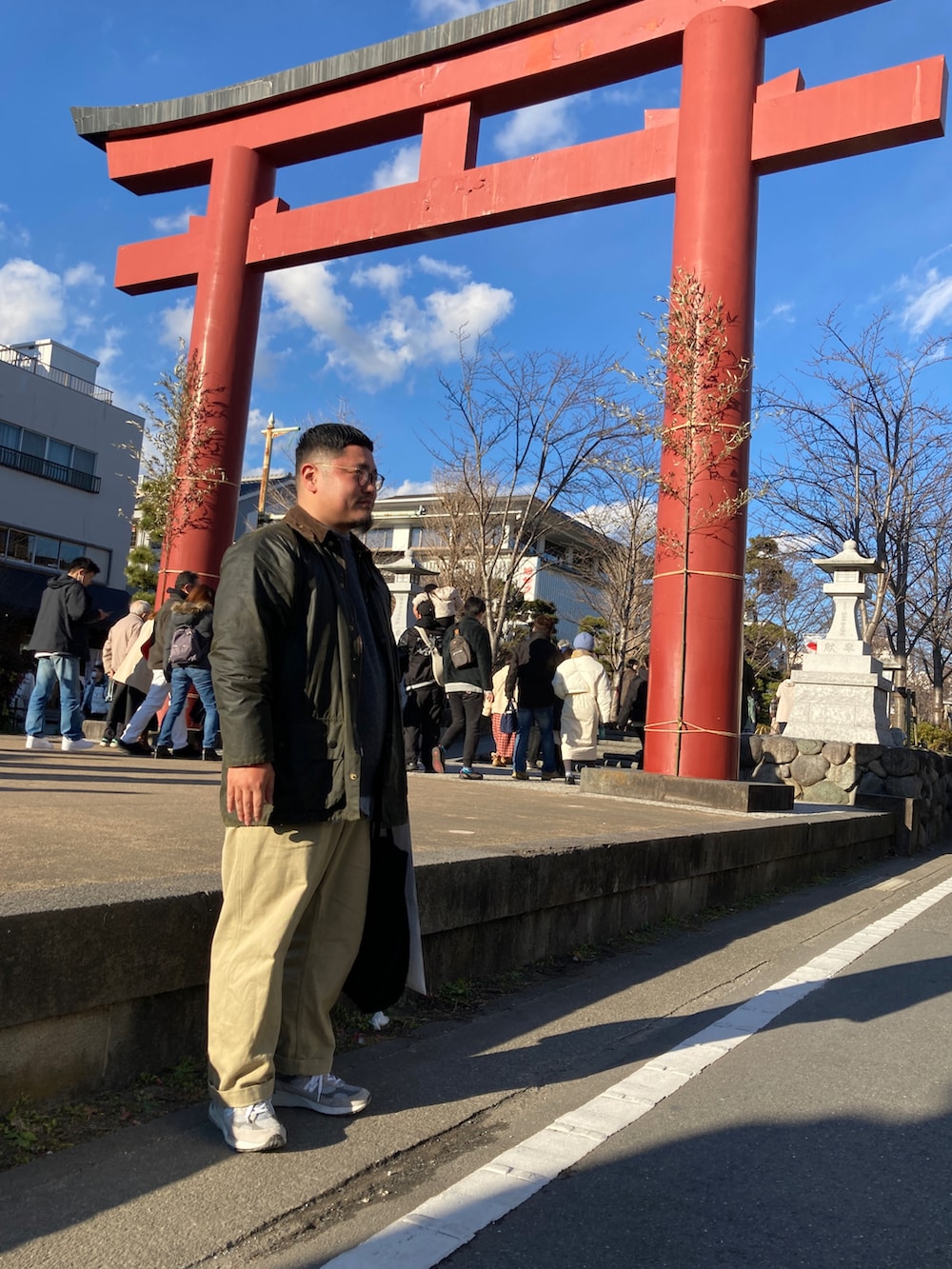 グレー系のスニーカー、ベージュ系のチノパンツ、グレー系のニット/セーターを着用したメンズの冬コーディネートの3枚目の写真