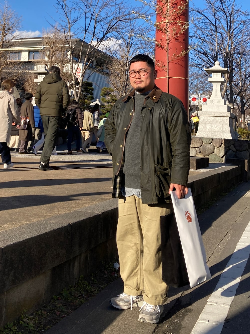 グレー系のスニーカー、ベージュ系のチノパンツ、グレー系のニット/セーターを着用したメンズの冬コーディネートの2枚目の写真