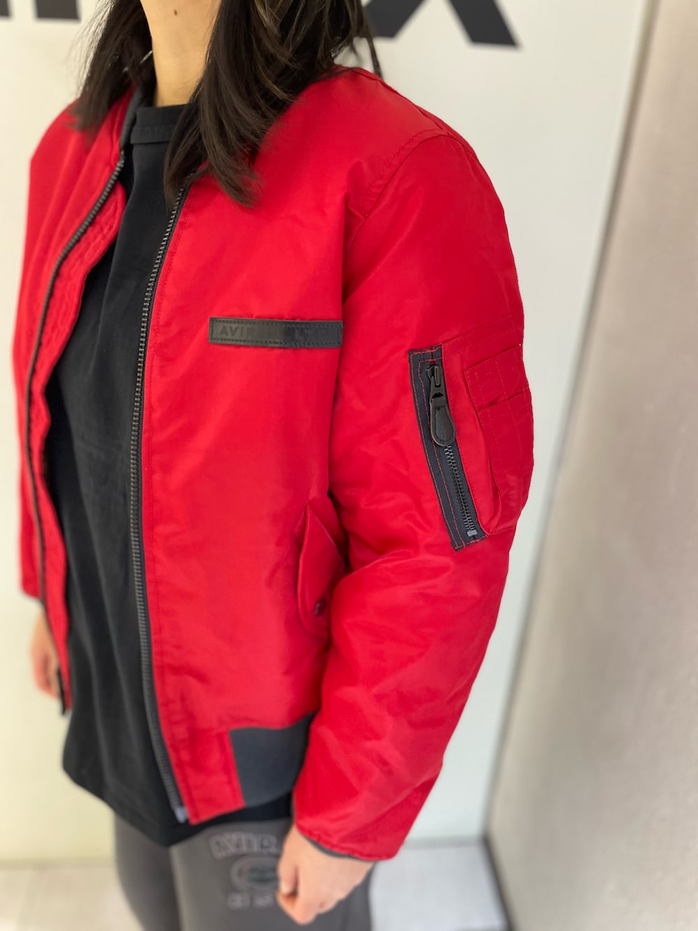 グレー系のスウェットパンツ、ブラック系のTシャツ/カットソー、レッド系のMA-1を着用したレディースの秋コーディネートの3枚目の写真