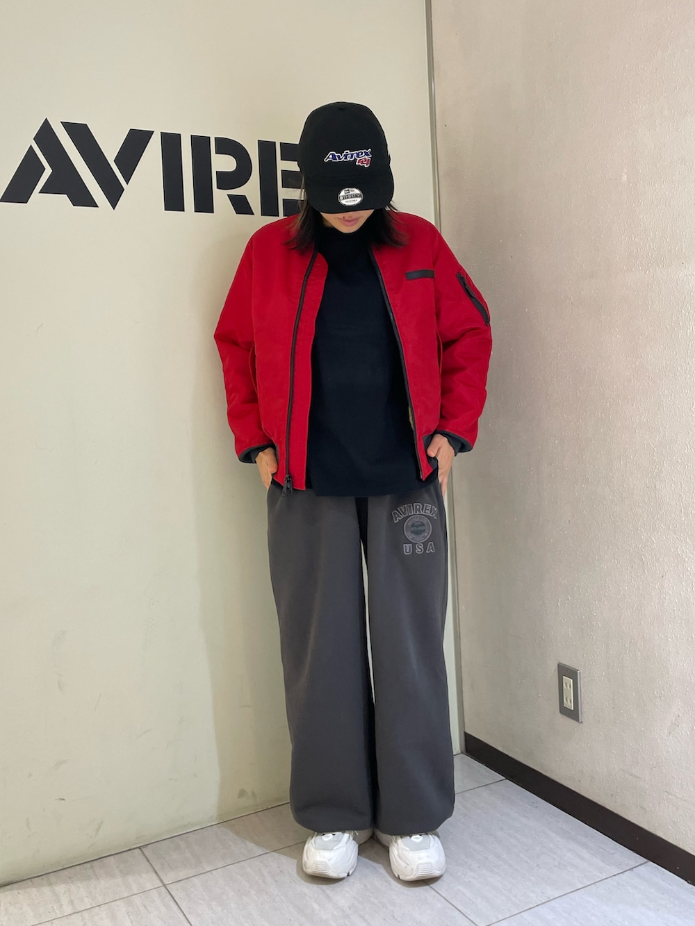 グレー系のスウェットパンツ、ブラック系のTシャツ/カットソー、レッド系のMA-1を着用したレディースの秋コーディネートの2枚目の写真