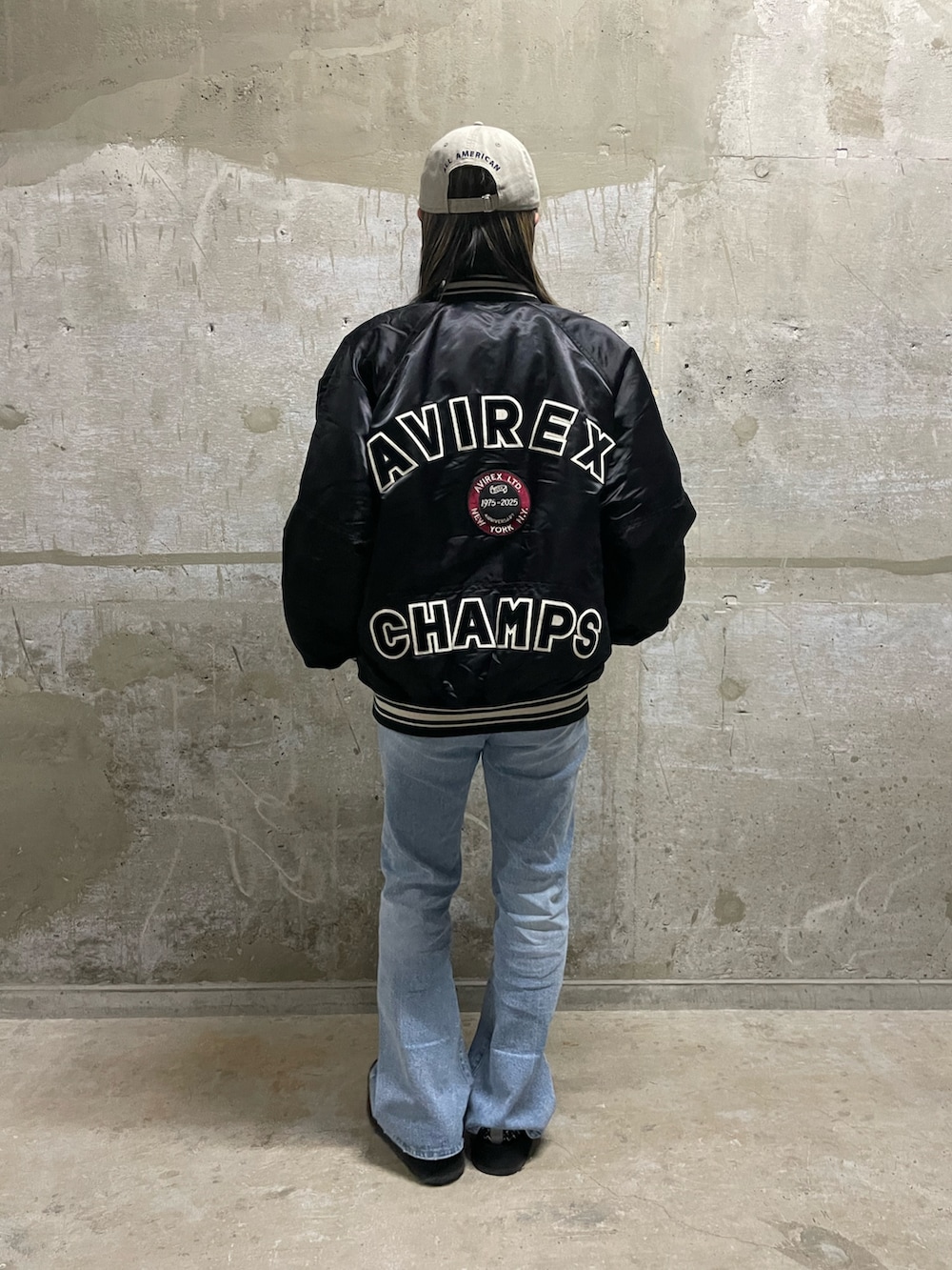 ホワイト系のTシャツ/カットソー、ブラック系のスタジャン、ブルー系のデニムパンツを着用したレディースの秋コーディネートの2枚目の写真