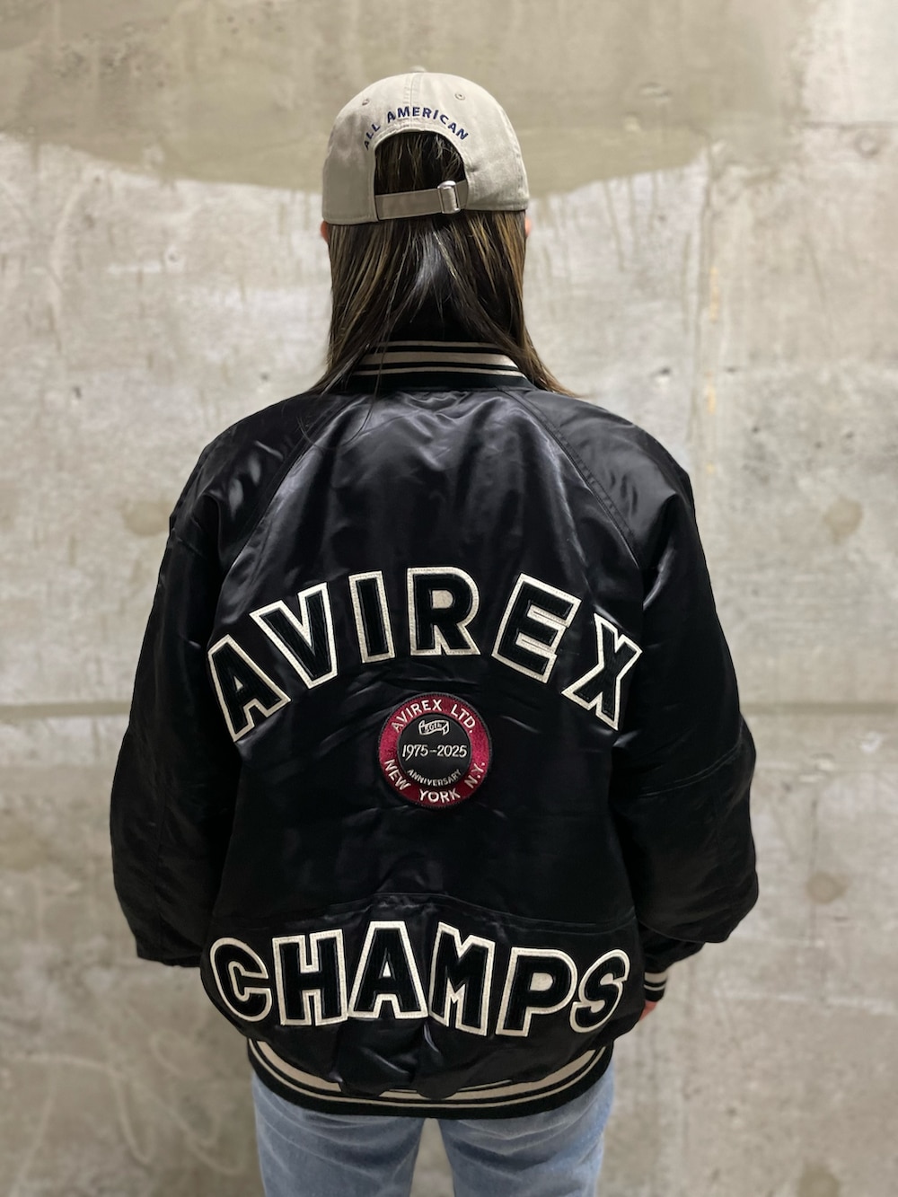 ホワイト系のTシャツ/カットソー、ブラック系のスタジャン、ブルー系のデニムパンツを着用したレディースの秋コーディネートの3枚目の写真