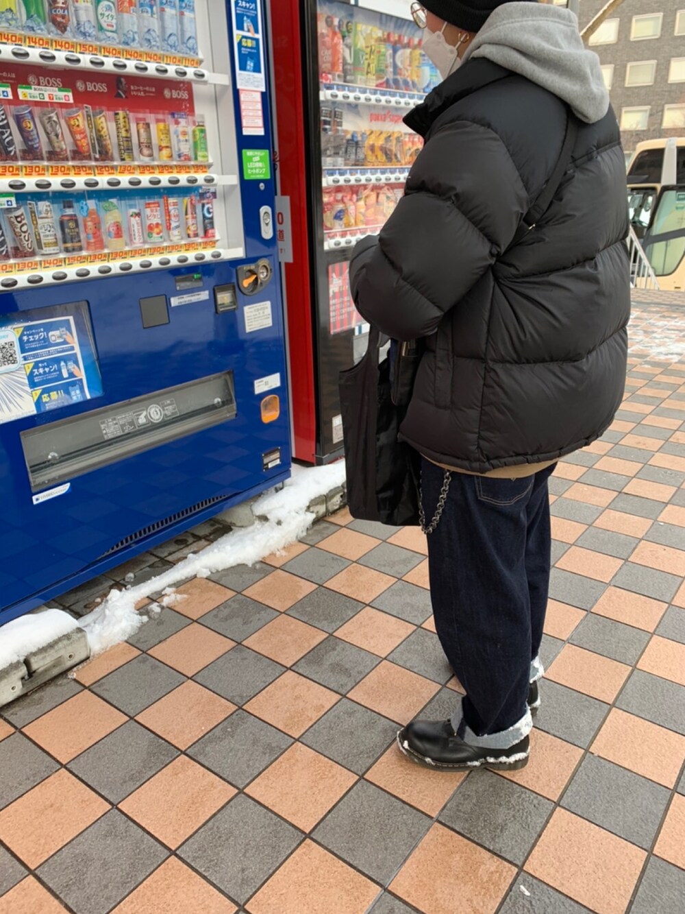 ブラック系のダウンジャケット/コート、グレー系のパーカー、その他のデニムパンツを着用したメンズの春コーディネートの2枚目の写真