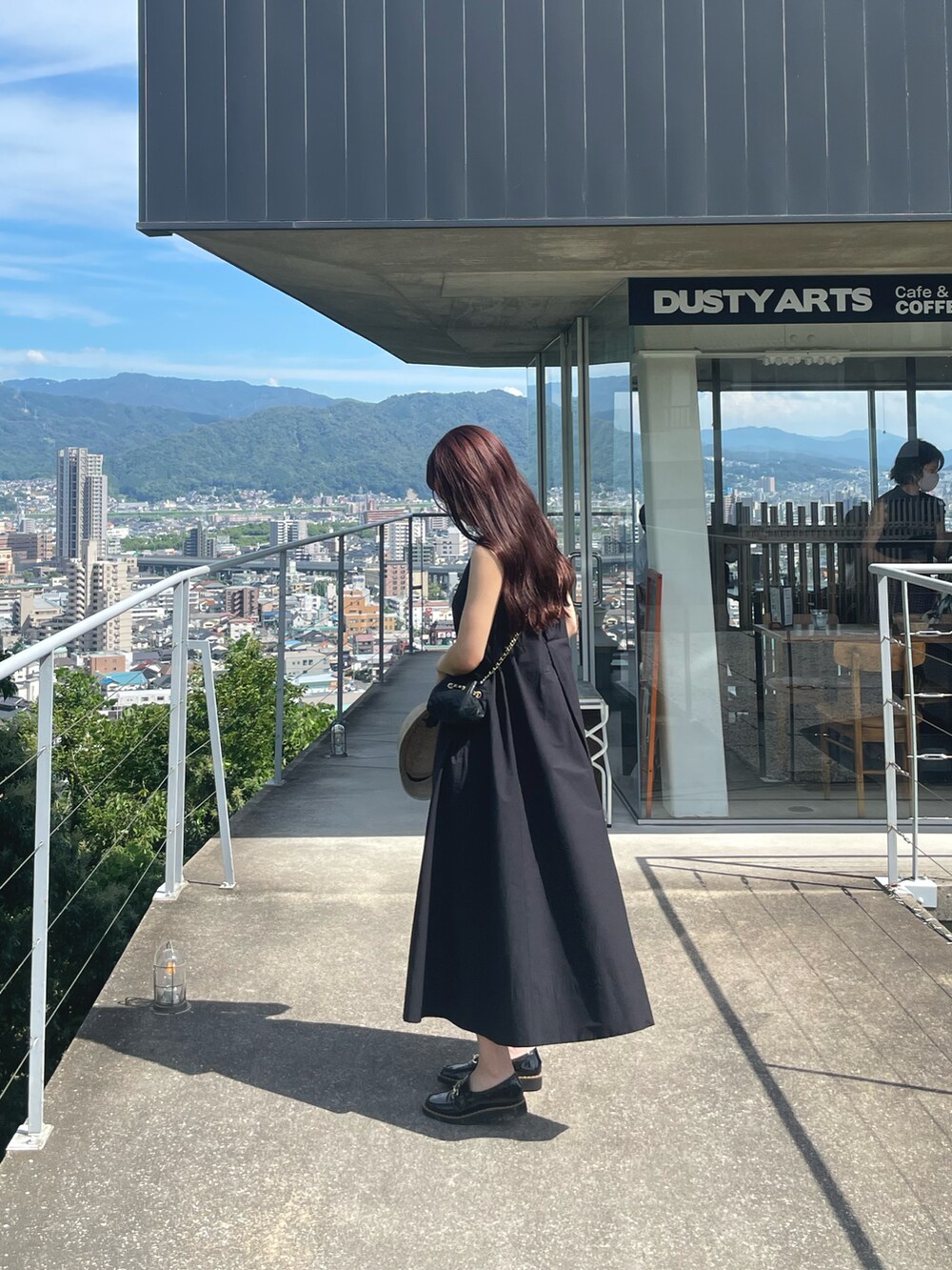 ブラック系のワンピース、ブラック系のシューズ、ブラック系のショルダーバッグを着用したレディースの夏コーディネートの2枚目の写真