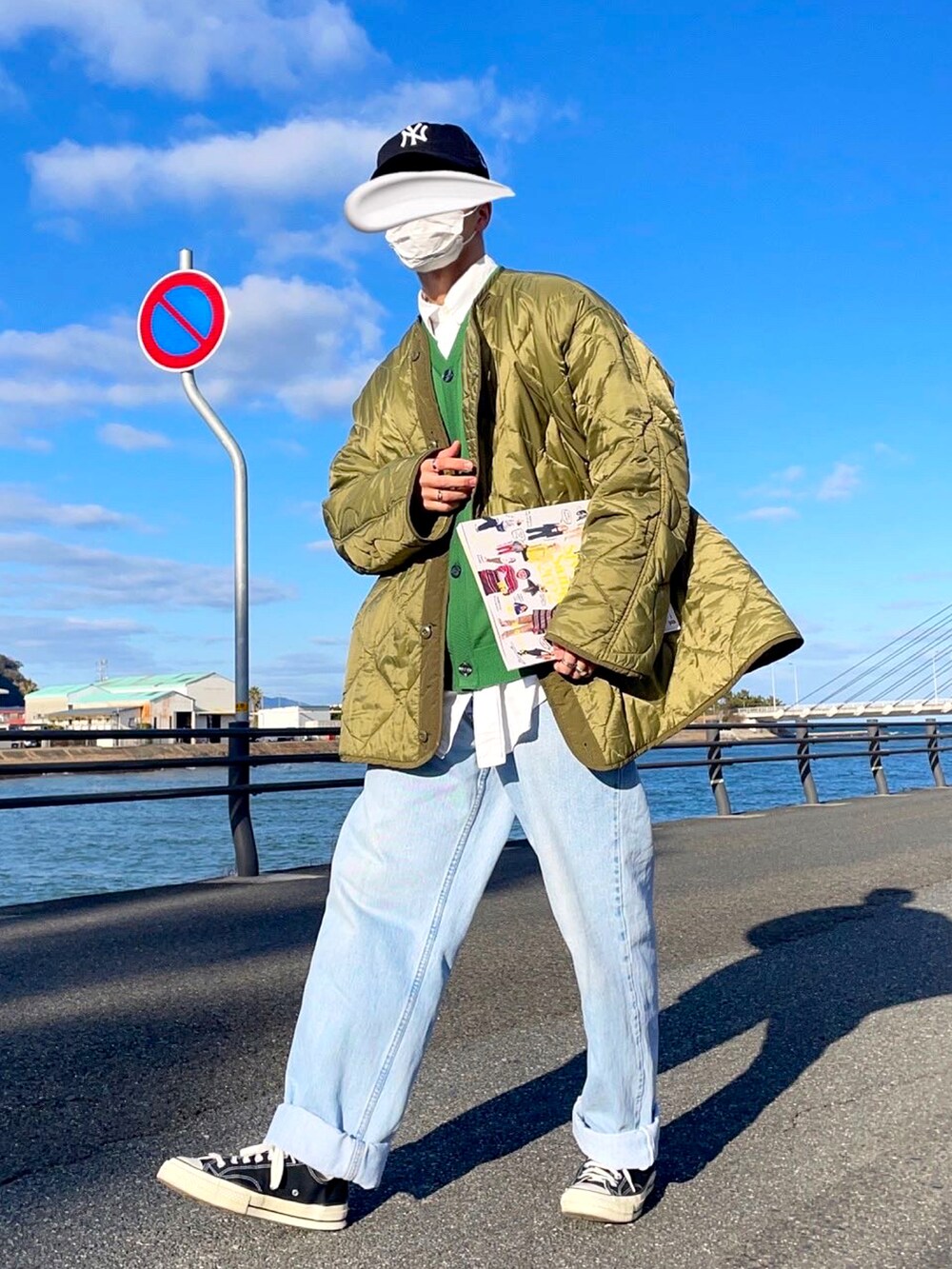 ブルー系のデニムパンツ、ブラック系のスニーカー、グリーン系のモッズコートを着用したメンズの冬コーディネートの2枚目の写真