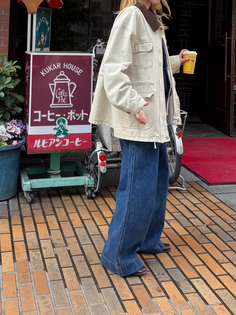 ベージュ系のカバーオール、イエロー系のハンドバッグを着用したレディースの冬コーディネートの2枚目の写真