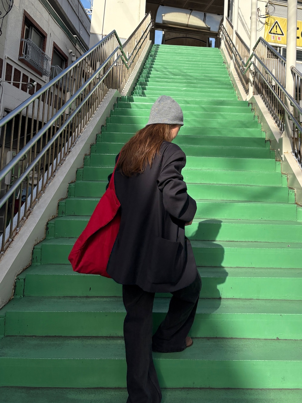 ブラック系のテーラードジャケット、ブラウン系のキャミソール、ブラック系のデニムパンツを着用したレディースの秋コーディネートの2枚目の写真