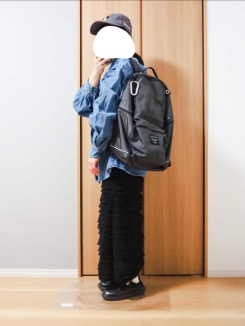 ブルー系のシャツ/ブラウス、グレー系のバックパック/リュック、ブラック系のスカートを着用したレディースの春コーディネートの2枚目の写真