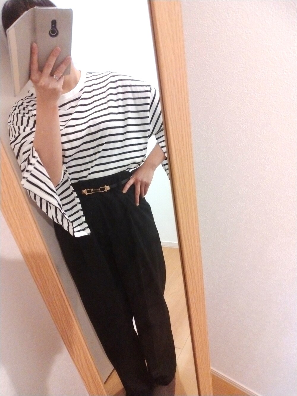 グリーン系のモッズコート、ホワイト系のTシャツ/カットソー、ブラック系のスラックスを着用したレディースの冬コーディネートの2枚目の写真