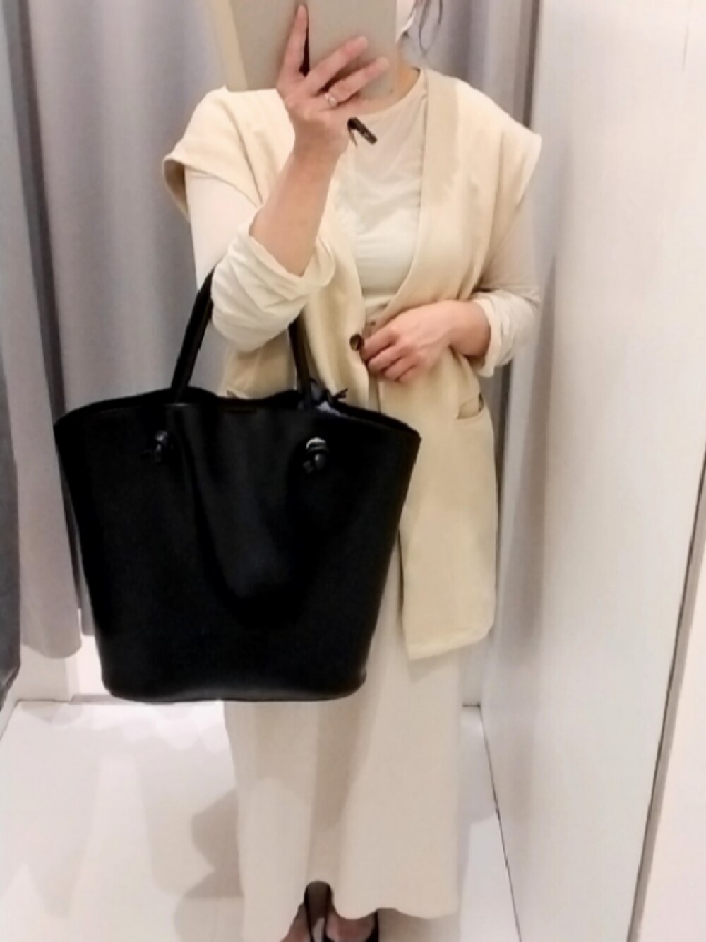 ブラック系のトートバッグ、ホワイト系のTシャツ/カットソー、ホワイト系のベストを着用したレディースの春コーディネートの2枚目の写真