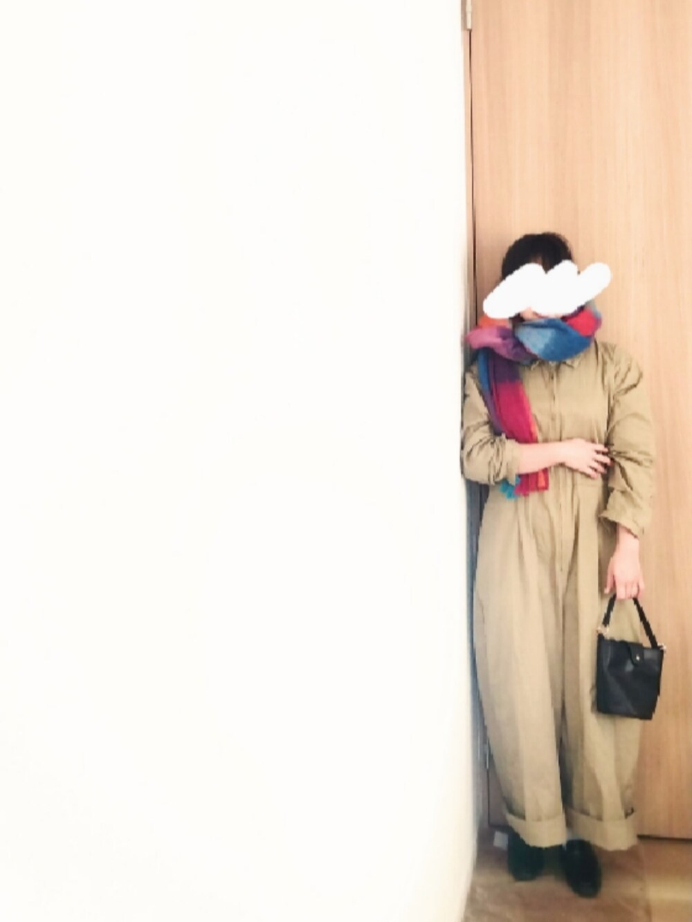 ホワイト系のノーカラーコート、ベージュ系のサロペット/オーバーオール、ブラック系のローファーを着用したレディースの秋コーディネートの2枚目の写真