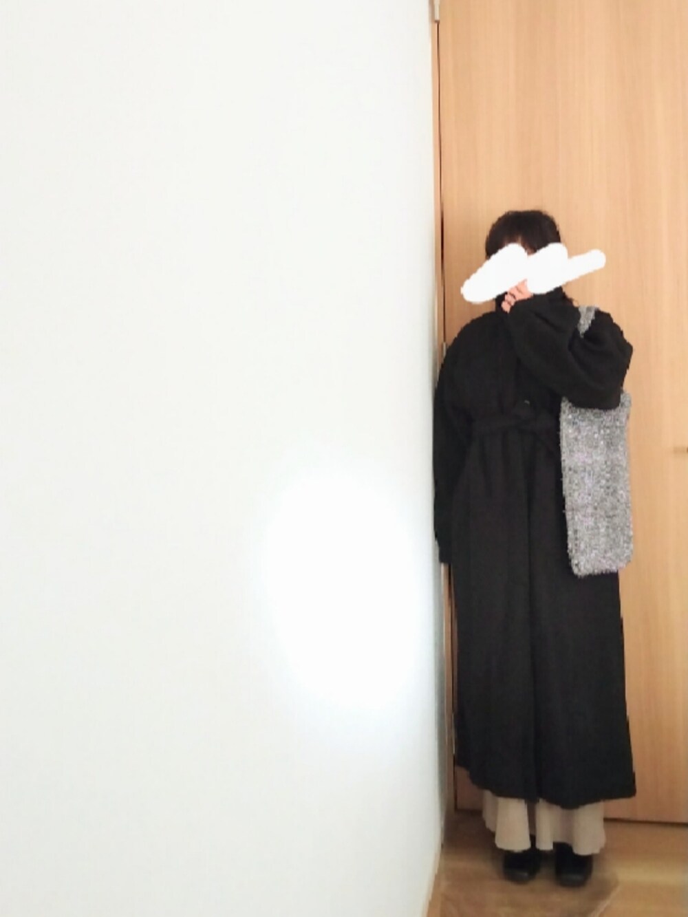 ベージュ系のワンピース、シルバー系のトートバッグ、ブラック系のステンカラーコートを着用したレディースの冬コーディネートの2枚目の写真