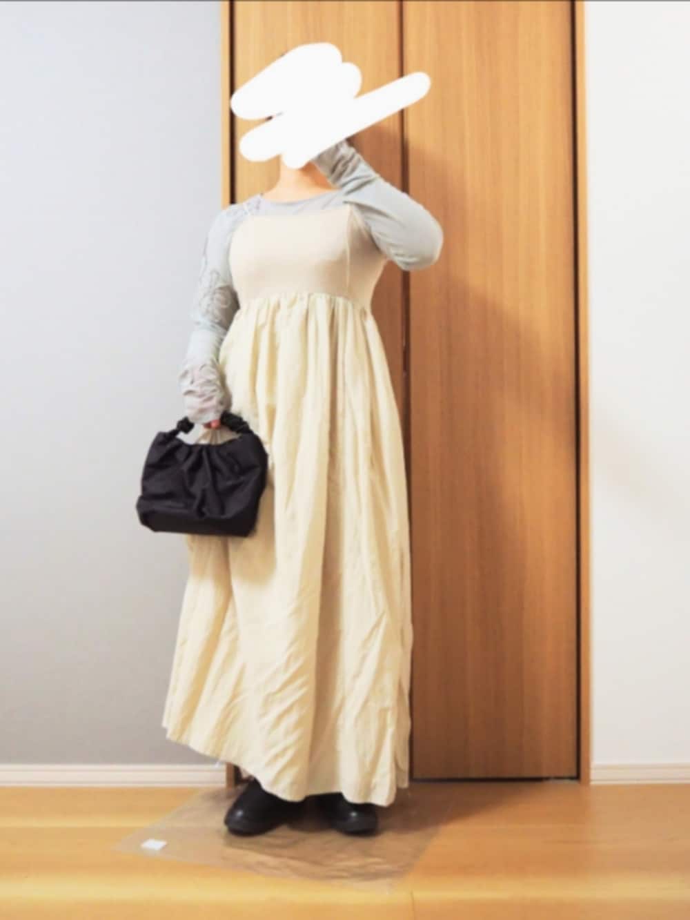 グレー系のTシャツ/カットソー、ホワイト系のノーカラーコート、ブラック系のハンドバッグを着用したレディースの冬コーディネートの2枚目の写真