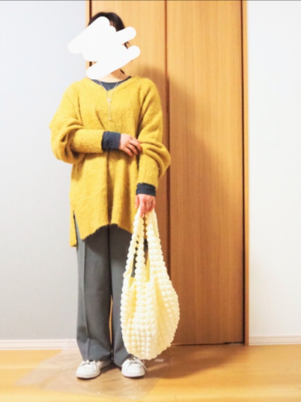 ブルー系のデニムジャケット、グレー系のTシャツ/カットソー、イエロー系のニット/セーターを着用したレディースの冬コーディネートの2枚目の写真